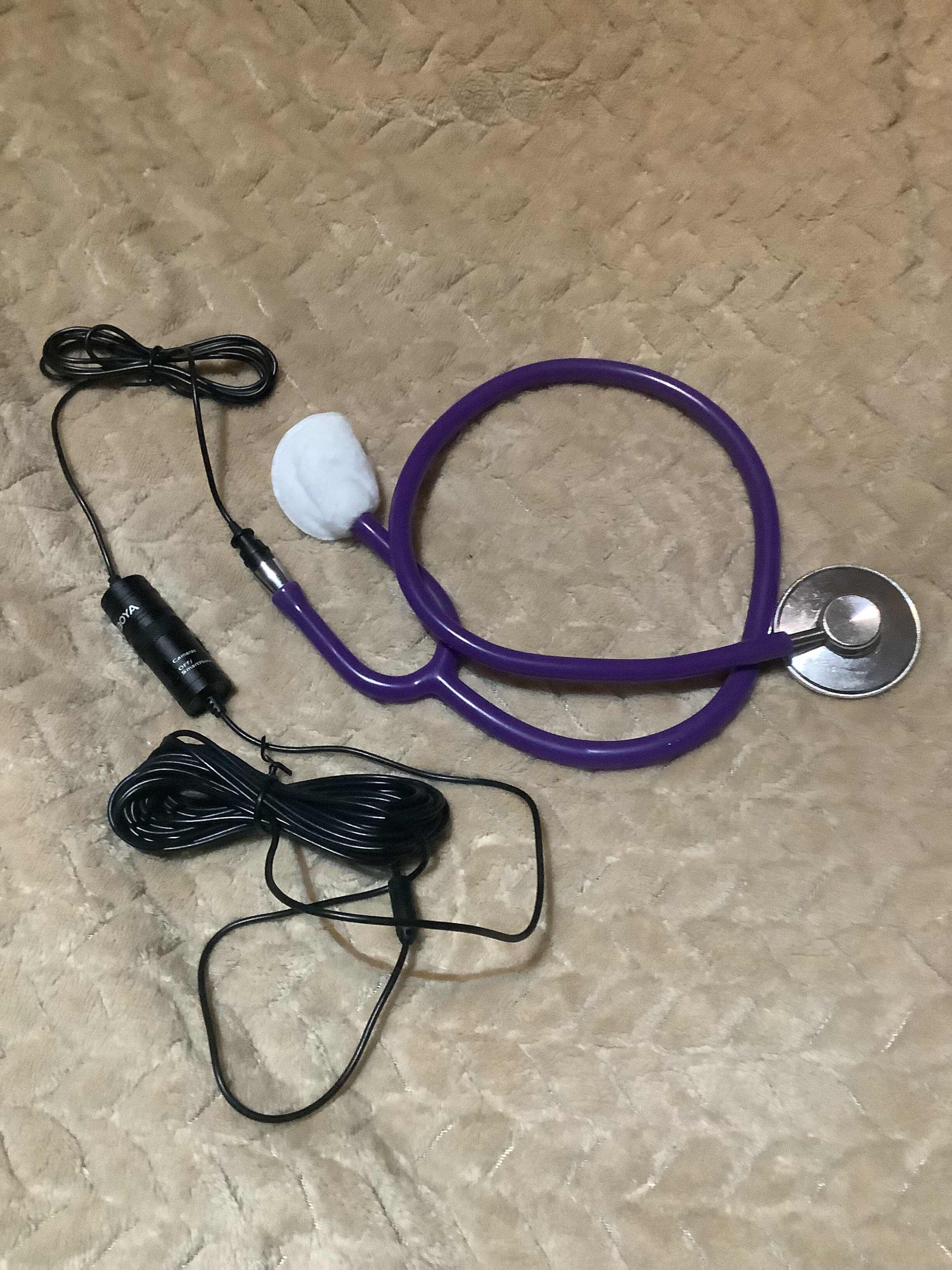 Purple stethoscope with its chestpiece connected to a lavalier microphone